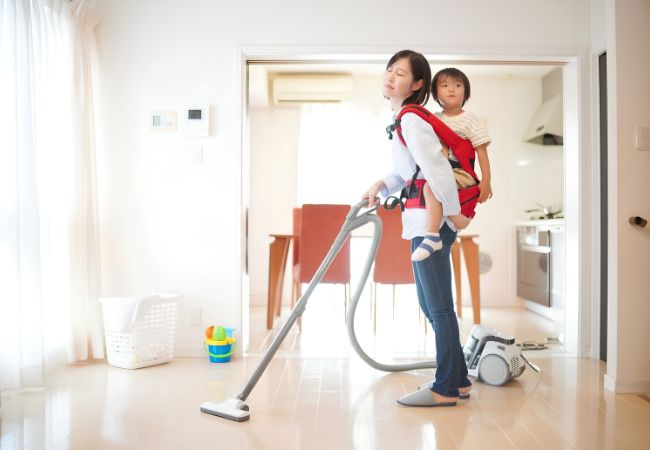Người giúp việc dọn nhà nấu ăn đang vệ sinh nhà cửa trong khi chăm sóc trẻ nhỏ