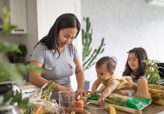 Người giúp việc dọn nhà nấu ăn đang chuẩn bị rau củ và nguyên liệu cho bữa ăn gia đình